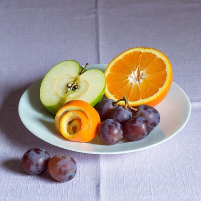 Sliced Apple Orange Plums on Plate