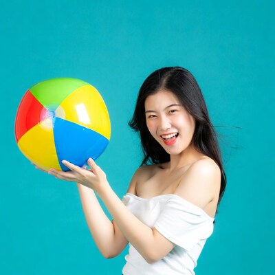 Asian woman holding colorful beach ball