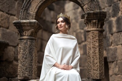 Woman in white gown with crown in ruins