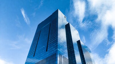 Tall blue glass skyscraper against sky