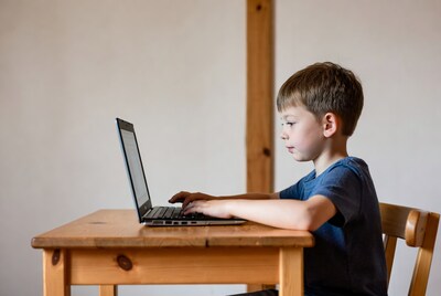 Boy typing on laptop at desk