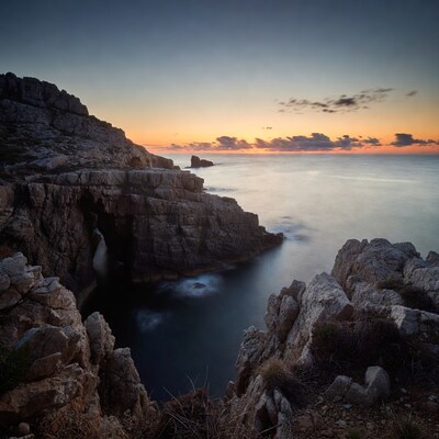 Sea Arch in Rocky Cliffs at Sunset