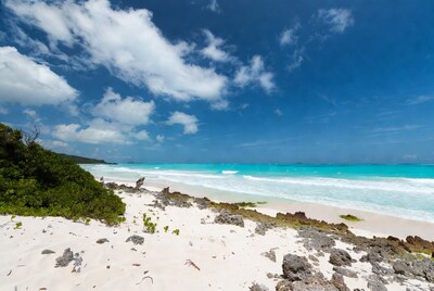 Turquoise tropical beach with rocks and waves