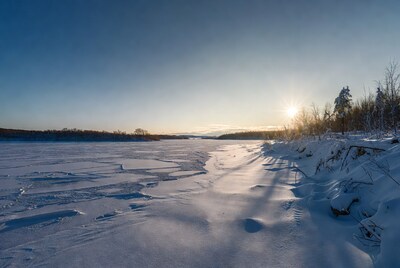 Frozen river sunset with snowy banks
