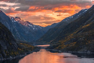 Sunset over snowy mountains and river