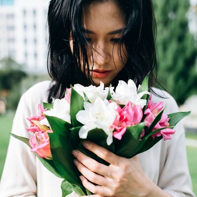 Asian woman holding white pink lilies