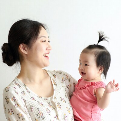 Asian mother holding smiling baby
