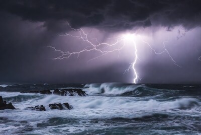 Lightning striking over stormy ocean waves