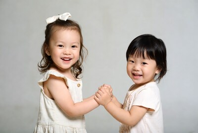 Asian toddlers shaking hands smiling