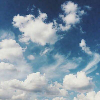 Fluffy white clouds in blue sky