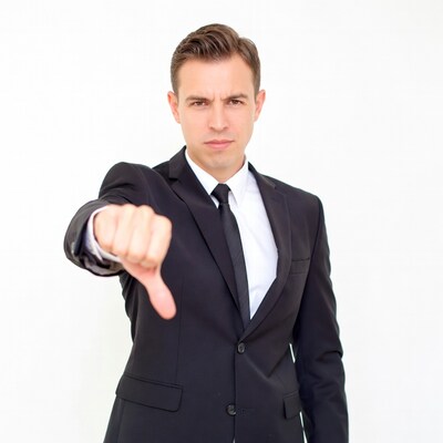 Man in suit showing thumbs down
