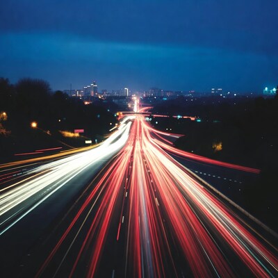 Night highway traffic light trails city skyline