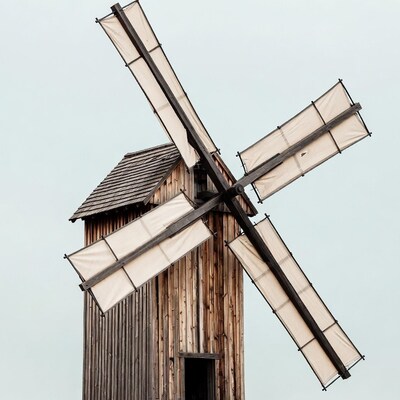 Traditional wooden windmill against sky