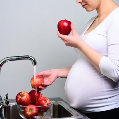 Pregnant woman washing red apples