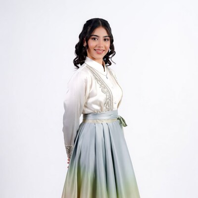 Young woman in embroidered white blouse gradient skirt