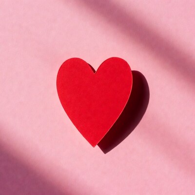 Red paper heart on pink background