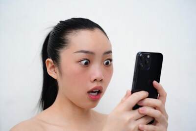 Asian woman shocked by phone