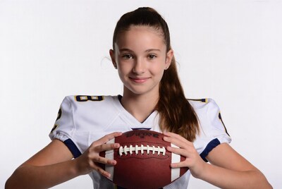 Girl holding football in jersey
