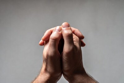 Man praying with clasped hands