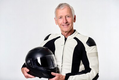 Elderly man holding motorcycle helmet