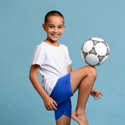 Boy balancing soccer ball on knee