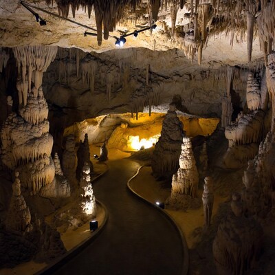 Illuminated Cave with Stalactites and Path