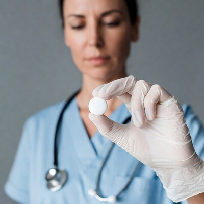 Nurse holding pill with gloves