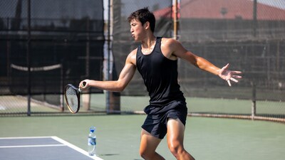 Asian man serving tennis racket