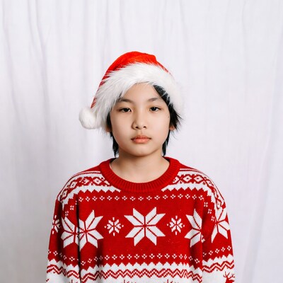 Asian boy in Santa hat and sweater