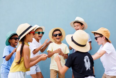 Diverse kids in hats applying sunscreen
