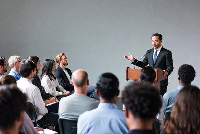 Man speaking at podium to audience