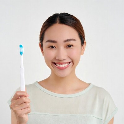 Asian woman holding toothbrush