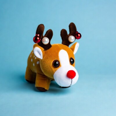 Cute plush reindeer toy on blue background