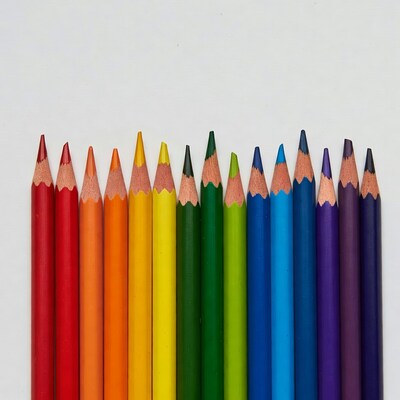 Rainbow colored pencils on white background
