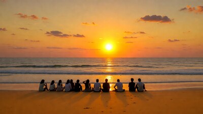 Group sitting on beach at sunset