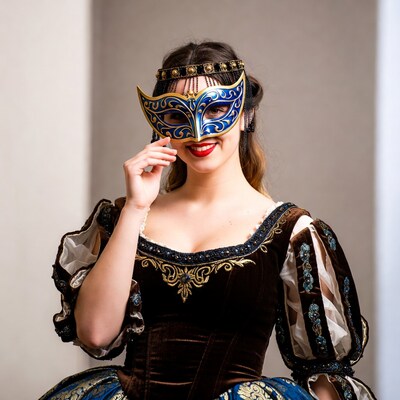 Woman smiling behind blue Venetian mask