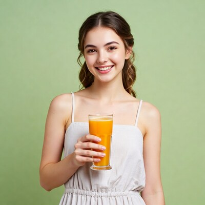 Young woman holding orange juice glass
