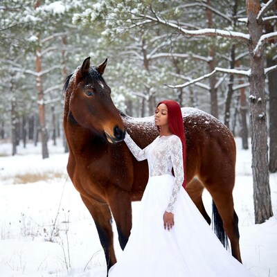 African-American woman with horse in snowy forest