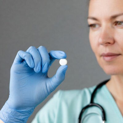 Nurse holding pill in blue gloves
