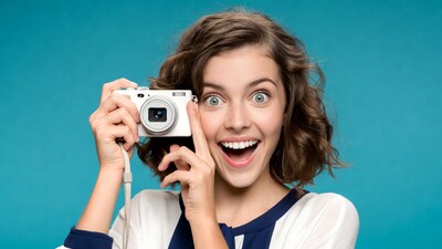 Excited girl holding white camera