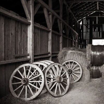 Wooden wagon wheels and hay bales in barn