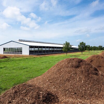 Modern metal barn with wood chip piles