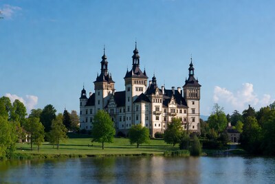 Castle by lake with green lawns