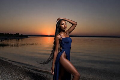 African-American woman in blue dress at sunset lake