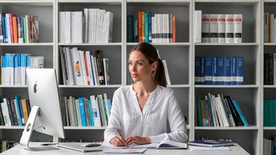 Woman working at desk with bookshelves