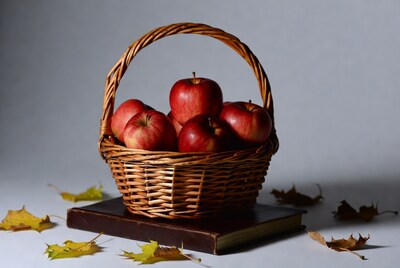Red Apples in Wicker Basket with Autumn Leaves