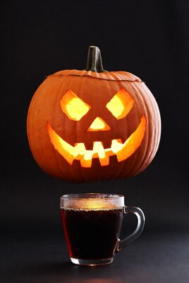 Lit Jack-o-Lantern above Coffee Mug