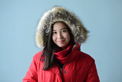 Asian woman smiling in red fur hood jacket