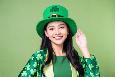 Asian woman in shamrock hat and green outfit