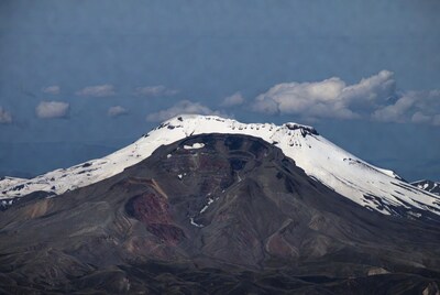 Snow-capped volcano under blue sky